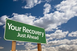 Your Recovery Green Road Sign Over Dramatic Clouds and Sky.